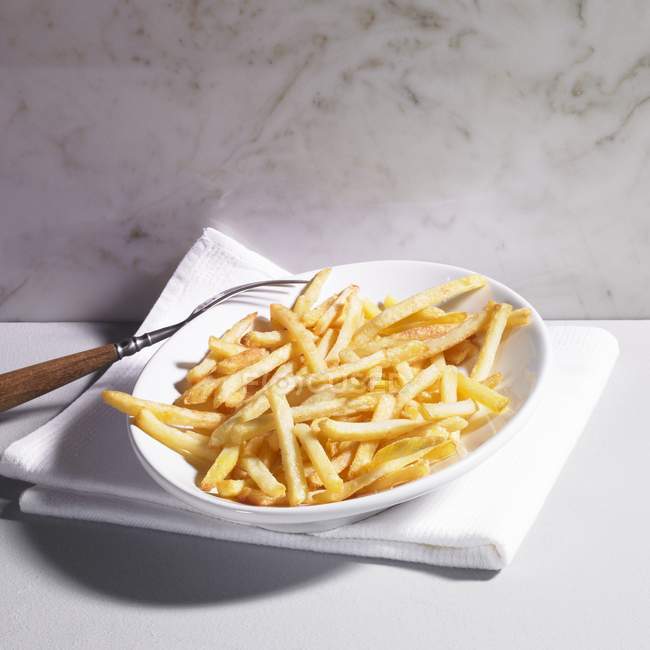 Тарелка картофеля фри с вилкой — стоковое фото