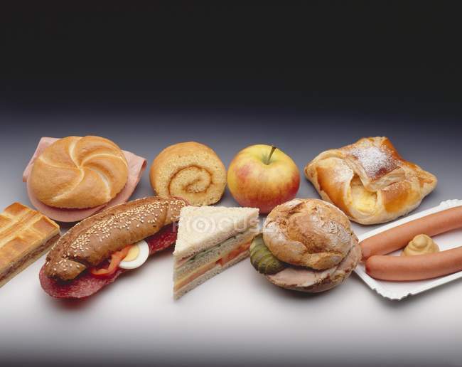 Assorted snacks, baked goods, filled rolls and sausages — Stock Photo