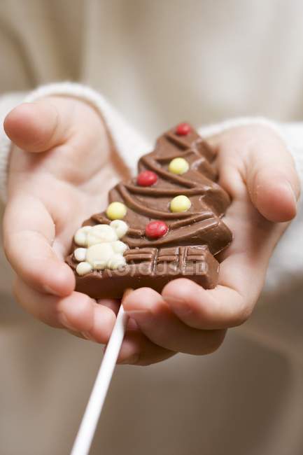 Enfant tenant un sapin de Noël chocolat — Photo de stock
