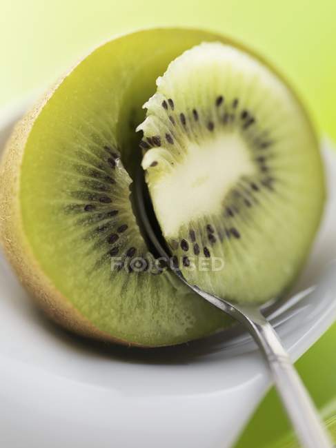Spooning out kiwi — Stock Photo