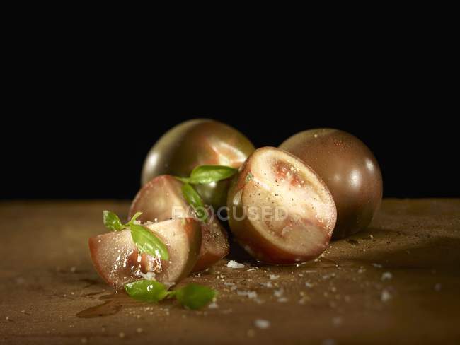 Kumato tomatoes with basil and salt — Stock Photo