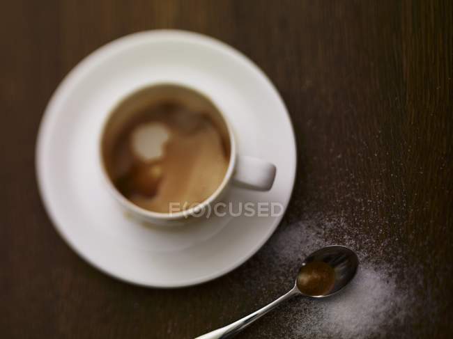 Cappuccino with sugar sprinkled next to it — Stock Photo