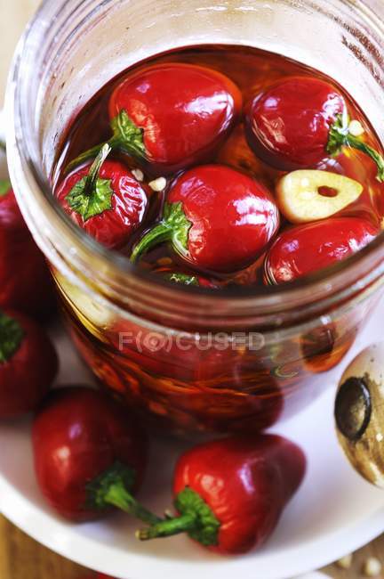 Peppers preserved in oil and garlic in jar — Stock Photo