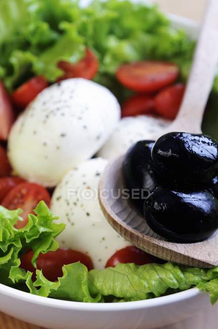 Black olives in wooden spoon — Stock Photo