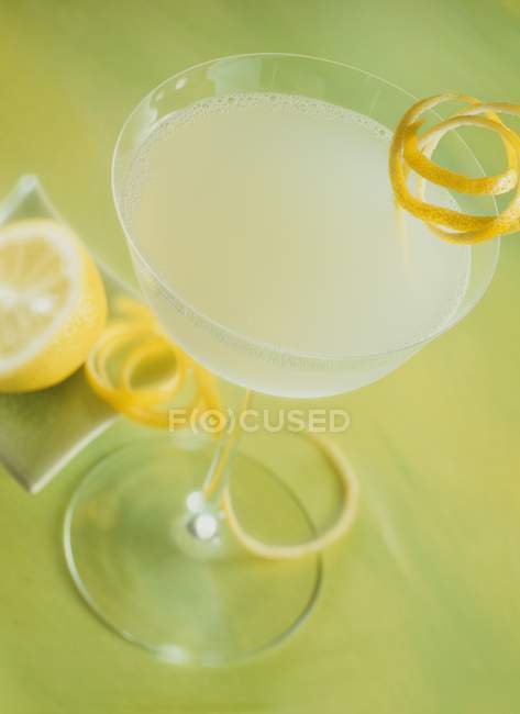 Cóctel con limón en copa de cóctel - foto de stock