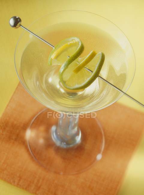 Closeup view of cocktail with lime slice on skewer — Stock Photo