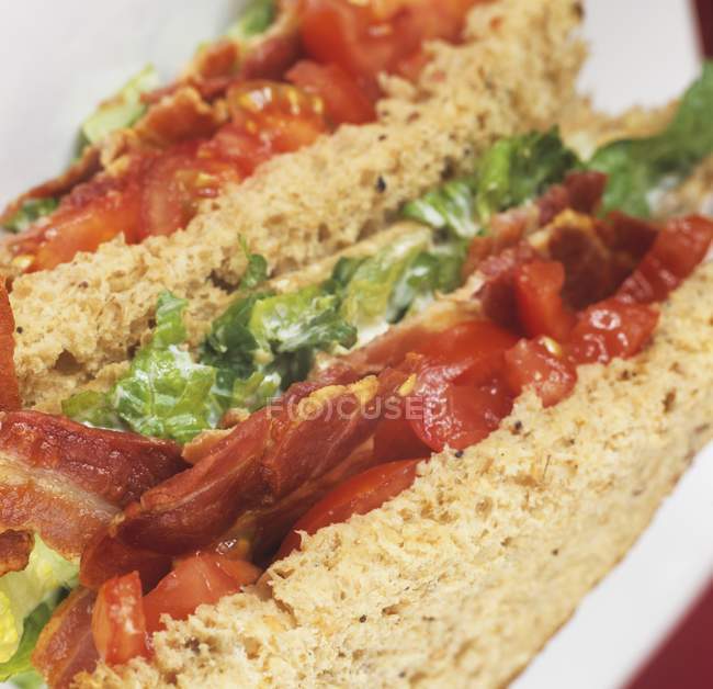 Vista de primer plano de sándwich con hojas de ensalada - foto de stock