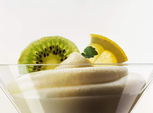 Vista de cerca de la crema de limón con kiwi y rodajas de limón en el tazón de postre - foto de stock