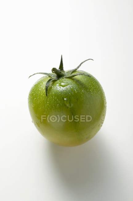 Tomate verde con gotas de agua - foto de stock