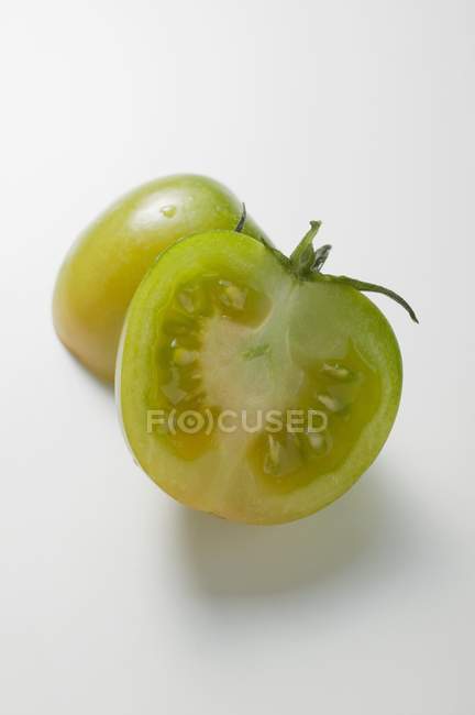 Green tomato halved — Stock Photo