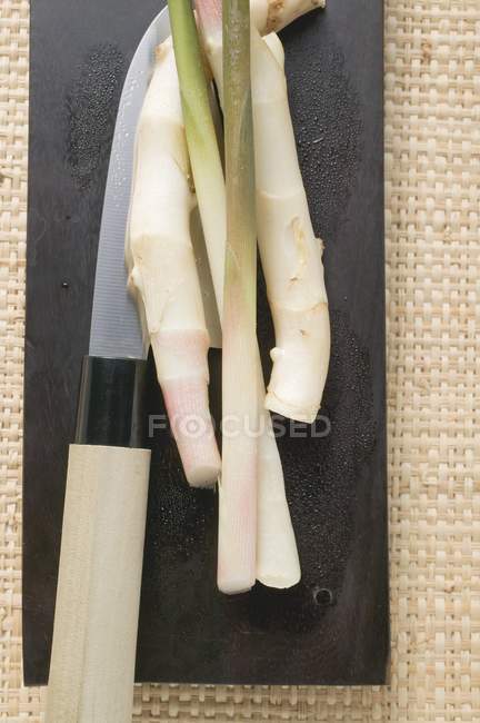Joven jengibre en tabla de cortar - foto de stock