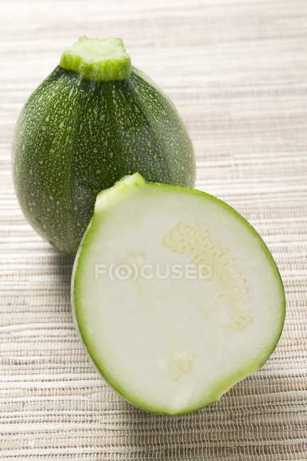 Whole and halved Round courgettes — Stock Photo