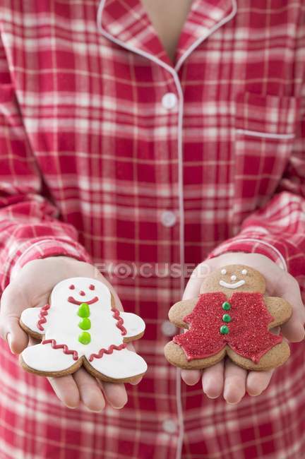 Woman holding gingerbread men — Stock Photo