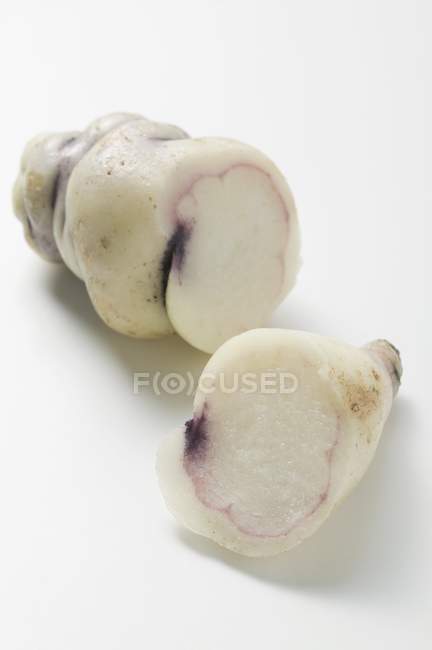Oca, cut into two pieces  on white surface — Stock Photo