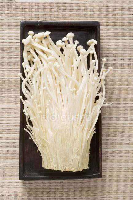 Enokitake mushrooms in wooden dish — Stock Photo