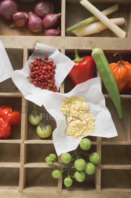 Various types of vegetables and spices in wooden type case — Stock Photo