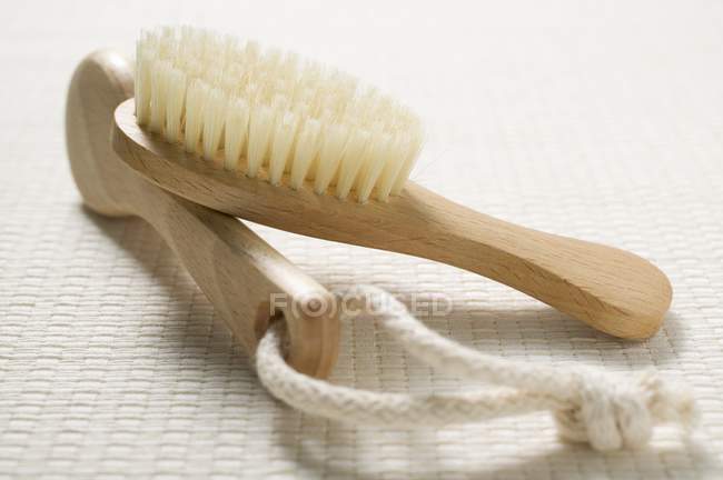 Primo piano vista di due diverse spazzole di legno con stringa sulla superficie bianca — Foto stock