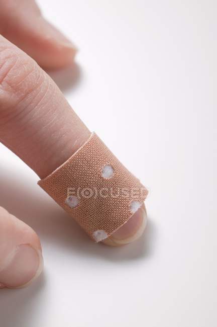 Vista de primer plano del dedo con yeso pegado - foto de stock