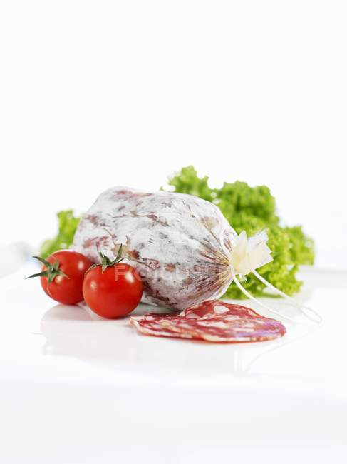 Salami with cherry tomatoes and latucce — Stock Photo