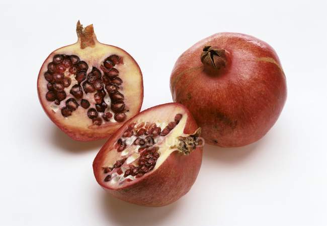 Whole and halved pomegranates — Stock Photo