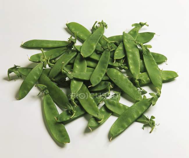 Closeup view of green Mangetout heap on white surface — Stock Photo