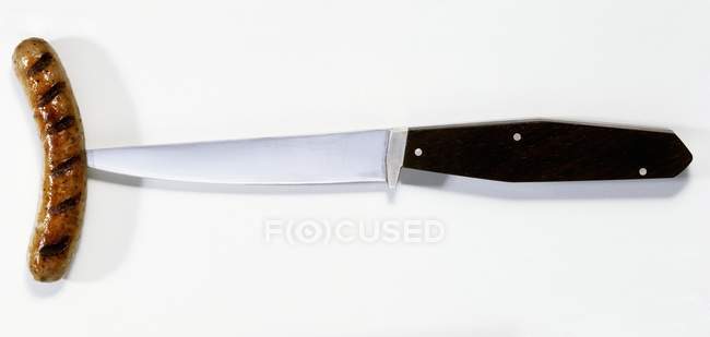 Primo piano vista dall'alto della salsiccia grigliata lancia sul coltello — Foto stock