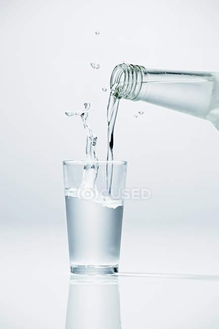 Выливание водки в стекло — стоковое фото