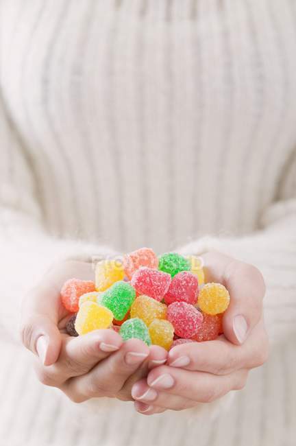 Mani che tengono caramelle gelatina — Foto stock