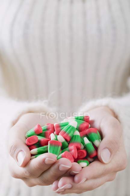 Female hands holding candy corn — Stock Photo