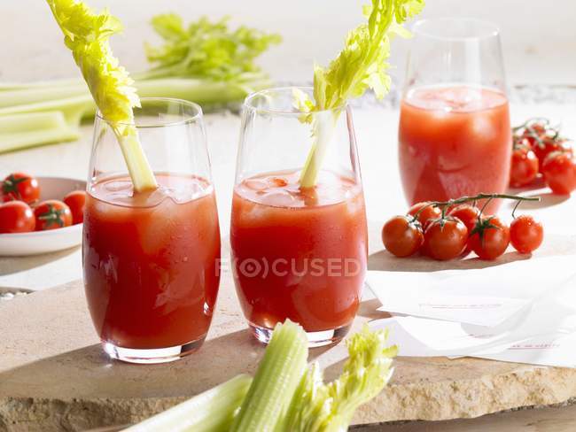 Крупный план коктейлей Кровавой Мэри с сельдереем и помидорами — стоковое фото