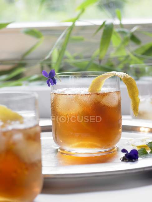 Холодный чай с лимонной кожурой в стакане — стоковое фото