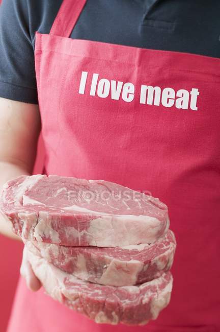 Homme tenant des steaks — Photo de stock