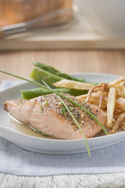 Salmon fillet with chips and green asparagus — Stock Photo