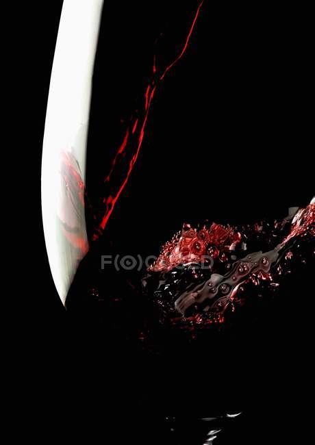 Verser du vin rouge dans un verre — Photo de stock