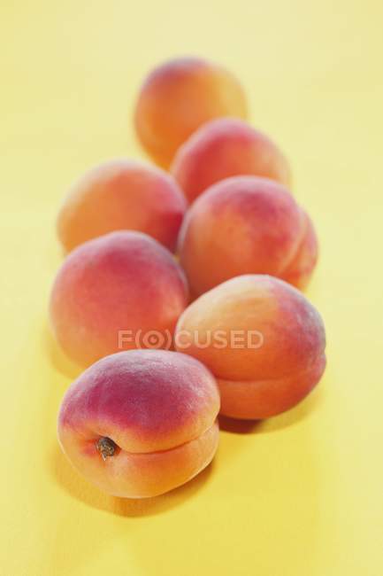 Несколько абрикосов на желтом — стоковое фото