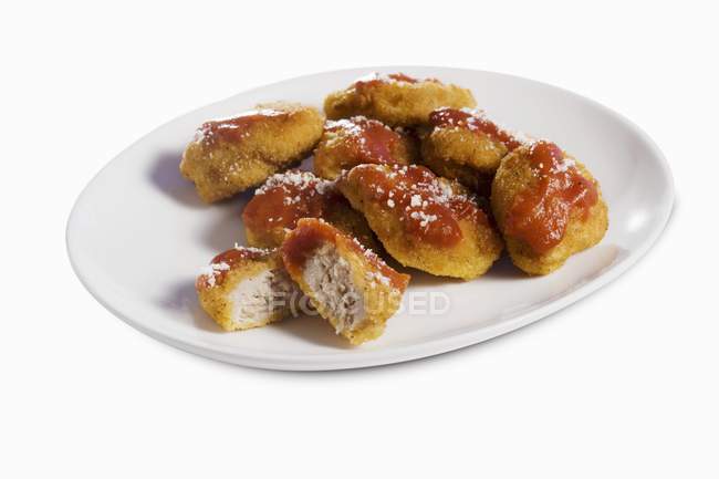 Vista de cerca de nuggets de pollo con ketchup en plato blanco - foto de stock