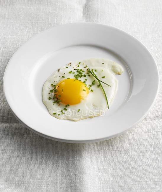 Piatto con uovo fritto ed erba cipollina — Foto stock