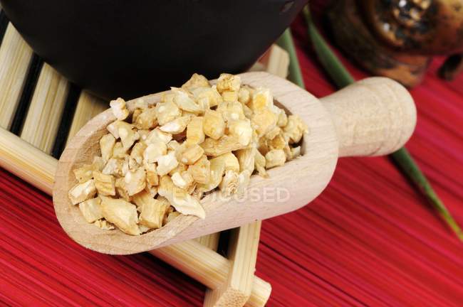 Closeup view of chopped Codonopsis root in wooden shovel on bamboo tray — Stock Photo
