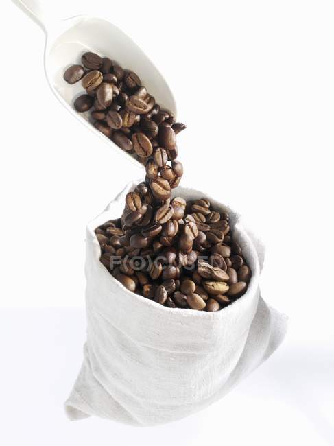 Verter granos de café en la bolsa - foto de stock