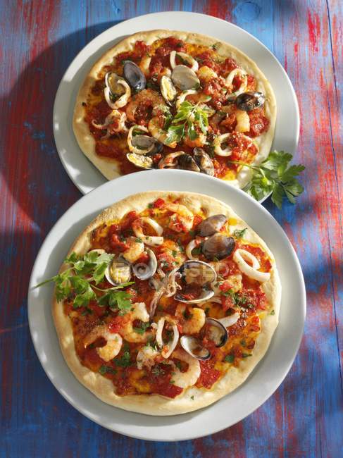 Seafood pizzas in plates — Stock Photo