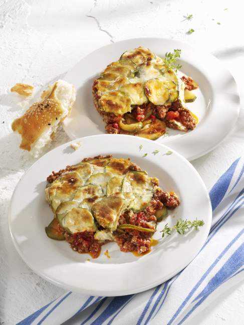 Moussaka with courgettes on plates — Stock Photo
