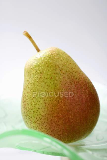 Pear on glass plate — Stock Photo