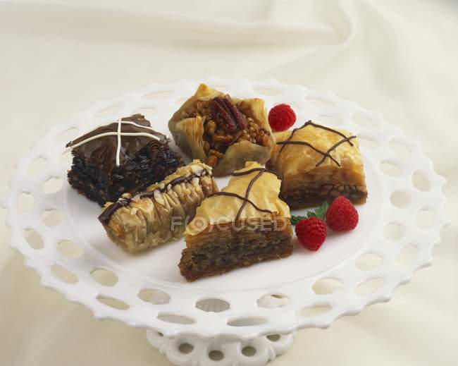 Closeup view of different Baklava pieces with raspberries on stand — Stock Photo