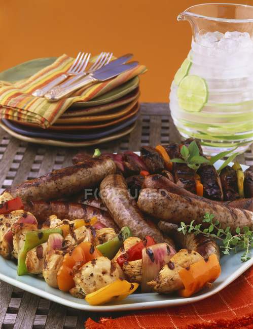 Vista de perto de prato de grelha com salsichas e kebabs — Fotografia de Stock