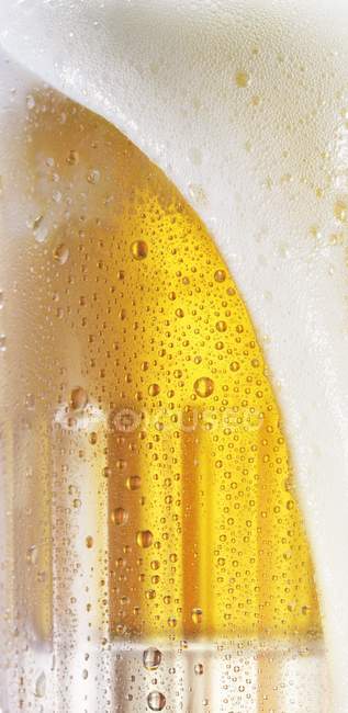 Mousse de bière coulant sur — Photo de stock