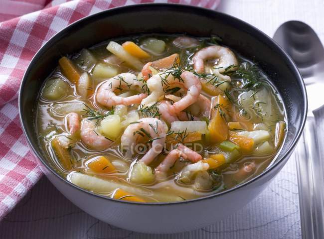 Sopa de camarão com legumes e endro na tigela preta sobre a mesa — Fotografia de Stock