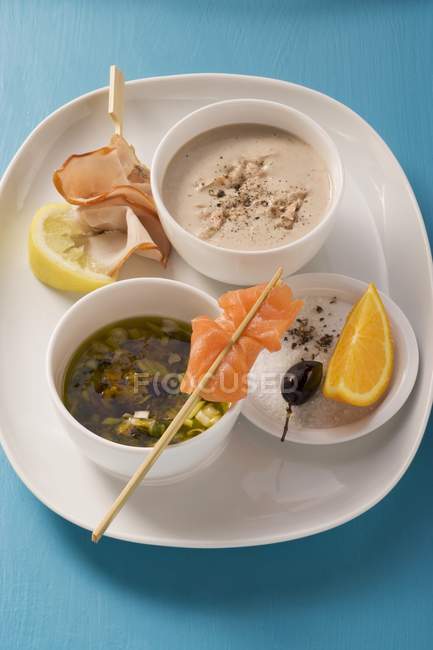 Pescado de atún y salsa de vino blanco y una marinada de aceitunas y alcaparras con naranjas en plato blanco - foto de stock