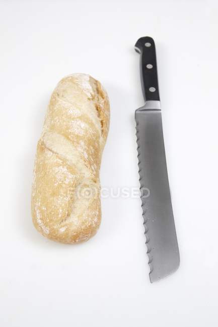 Baguette blanco y cuchillo - foto de stock