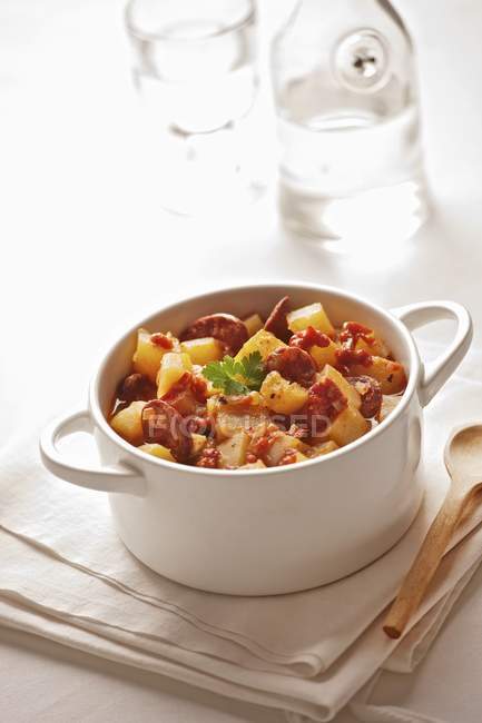Spanish potato soup with rioja wine in white saucepan over towel — Stock Photo