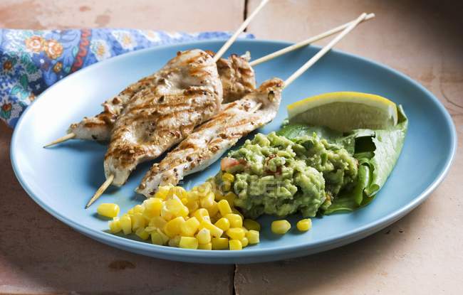 Chicken kebabs with sweetcorn and guacamole — Stock Photo